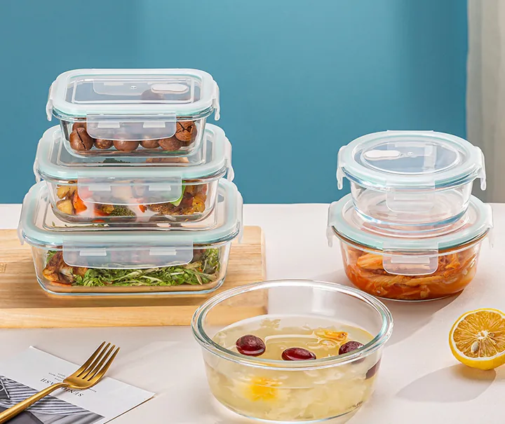 Assortiment de récipients alimentaires en verre, carrés et ronds, disposés sur une table à manger