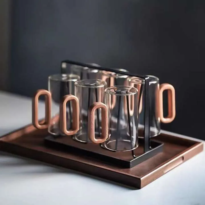 Verres en verre transparent avec des anses en bois, présentés sur un plateau et un support