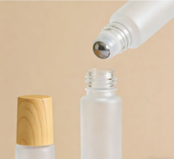 Frosted white glass roll on bottle with wood grain cap