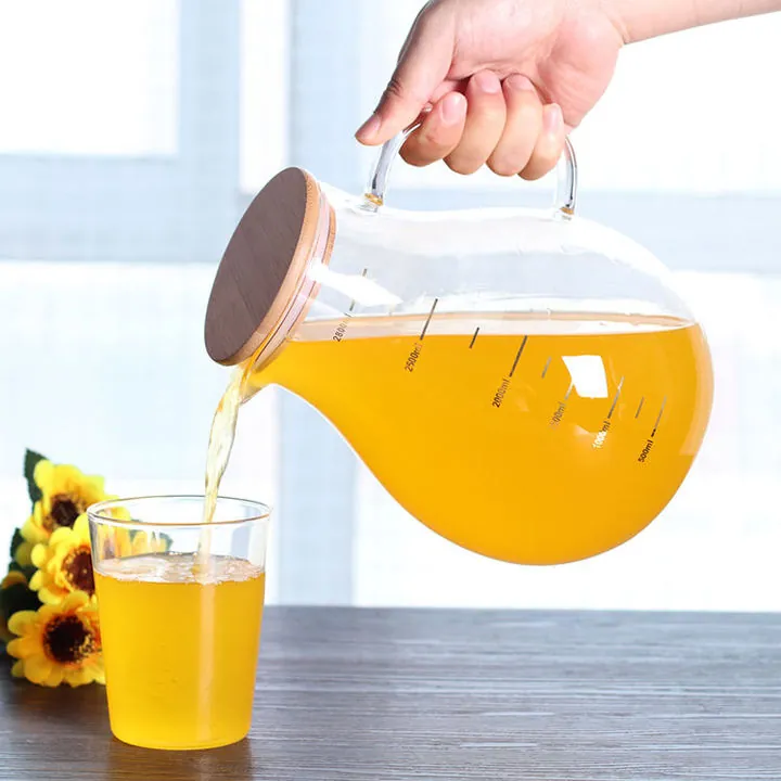 Pichet rond en verre avec couvercle en bois, servant à verser une boisson