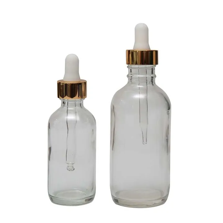 Two clear serum dropper bottles with gold caps and white tops