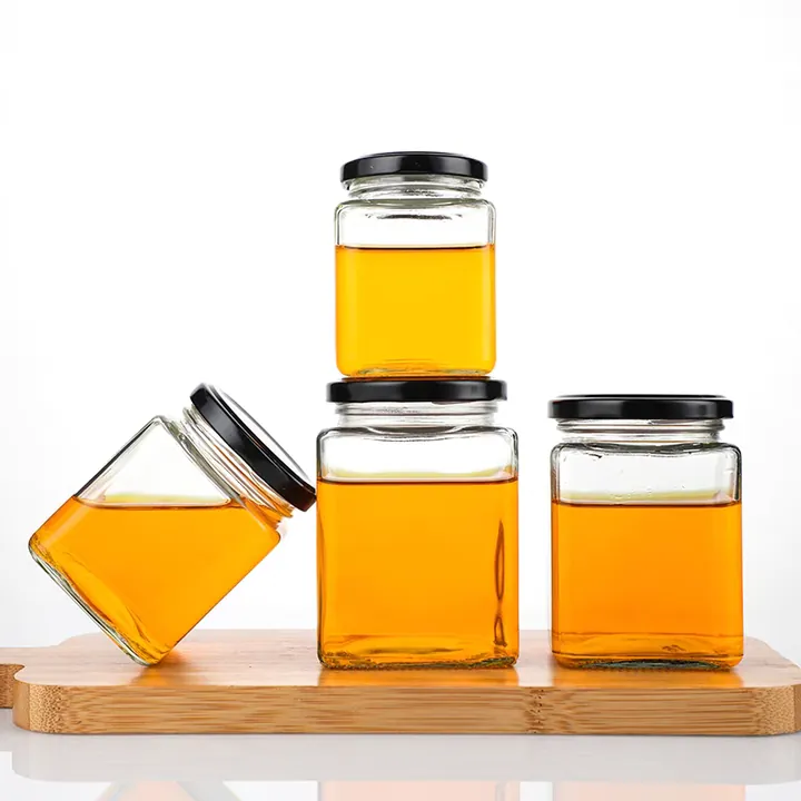 Square honey jars in different sizes arranged on a wooden tray