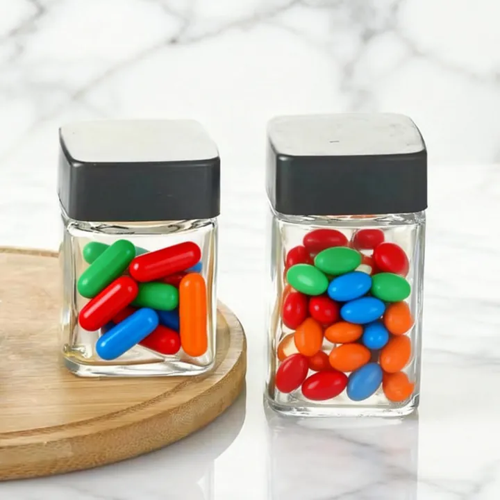 Square transparent pill jar with black cap and colorful capsules