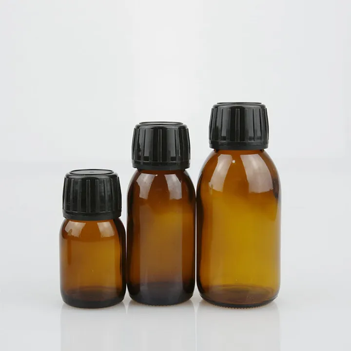 Three amber glass syrup bottles with black tamper evident caps