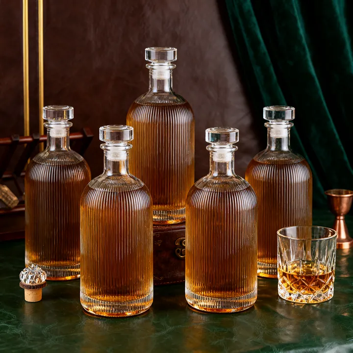 Ribbed glass whiskey bottles and glasses arranged in a bar scene