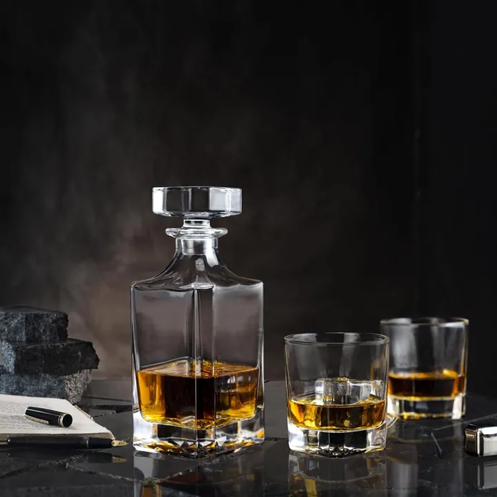 Carafe à whisky carrée avec deux verres, dans un décor sombre