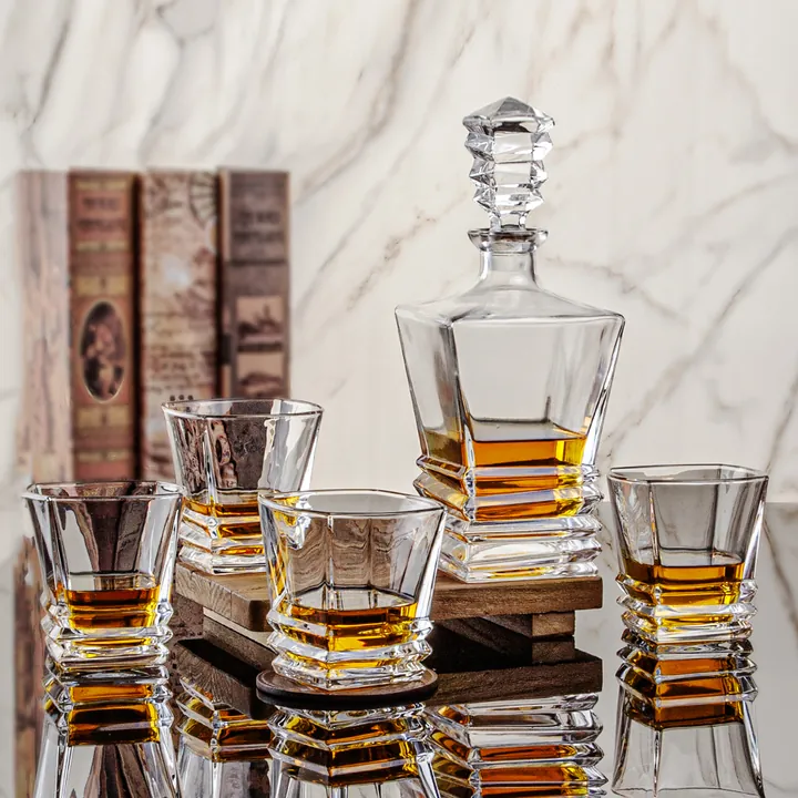 Une carafe à whisky et quatre verres sur la table à manger