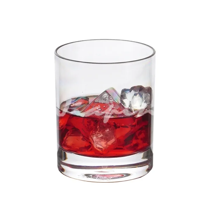 Straight transparent whiskey glass with red drink and ice
