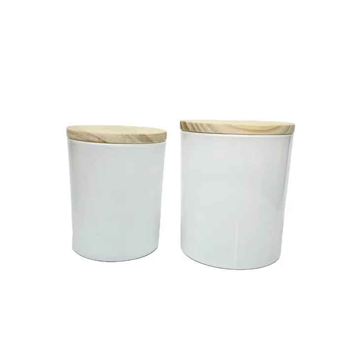 Two white straight candle jars with light wooden lids