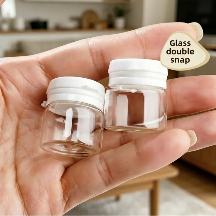 Two wide mouth clear glass vials with white double layer snap caps