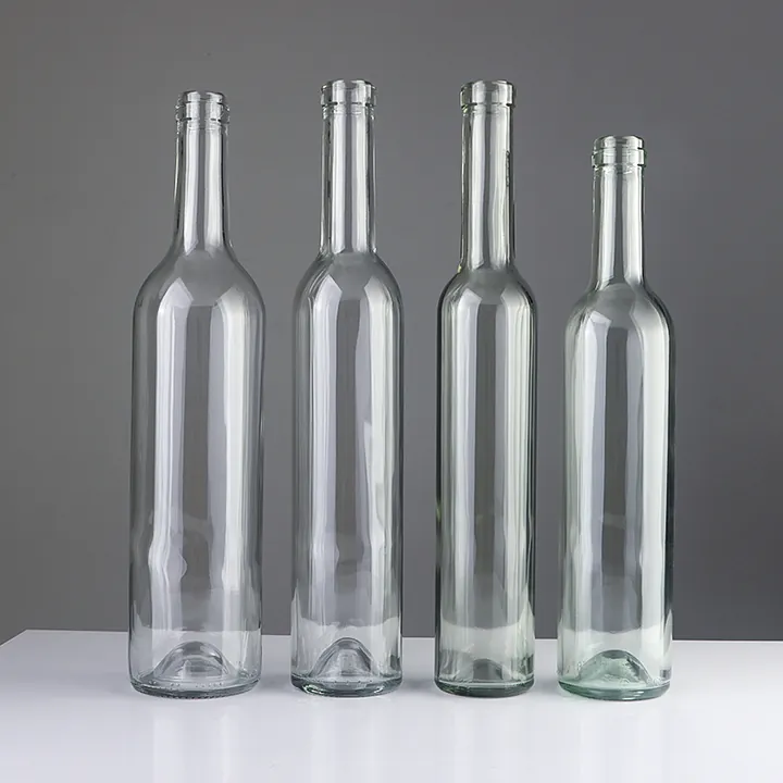 Vier Weinglasflaschen aus klarem Glas in unterschiedlichen Höhen
