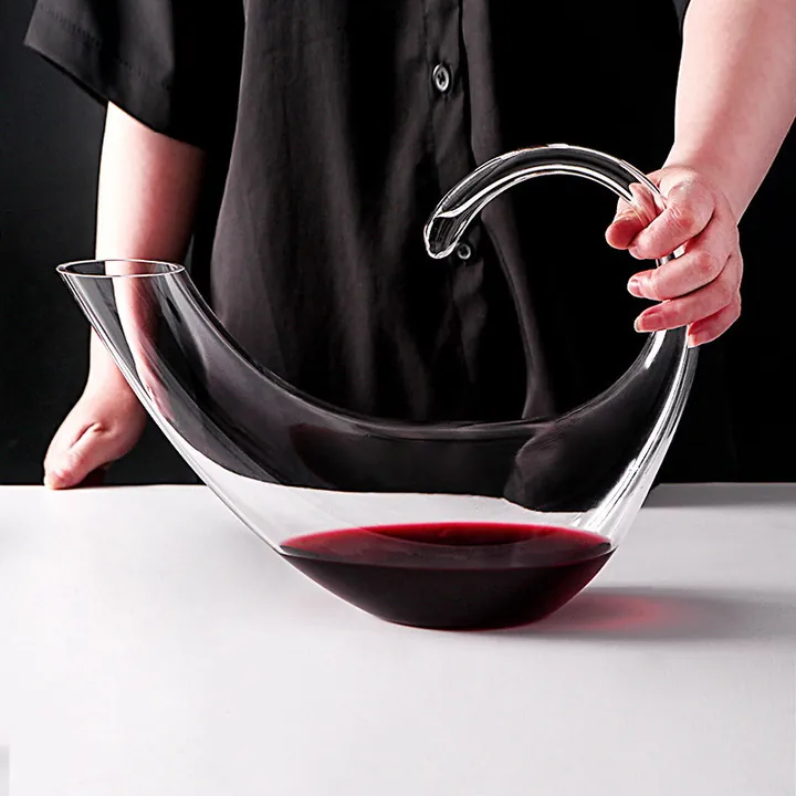 Curved transparent glass decanter with red wine