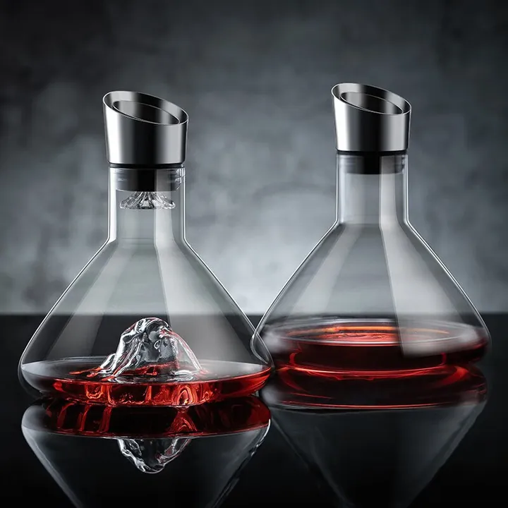 Two volcano shaped glass decanters with metal wine pourers