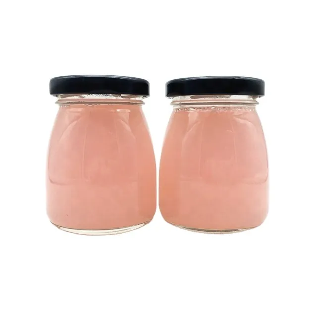 Two round yoghurt glass jars with pink contents and black metal lids