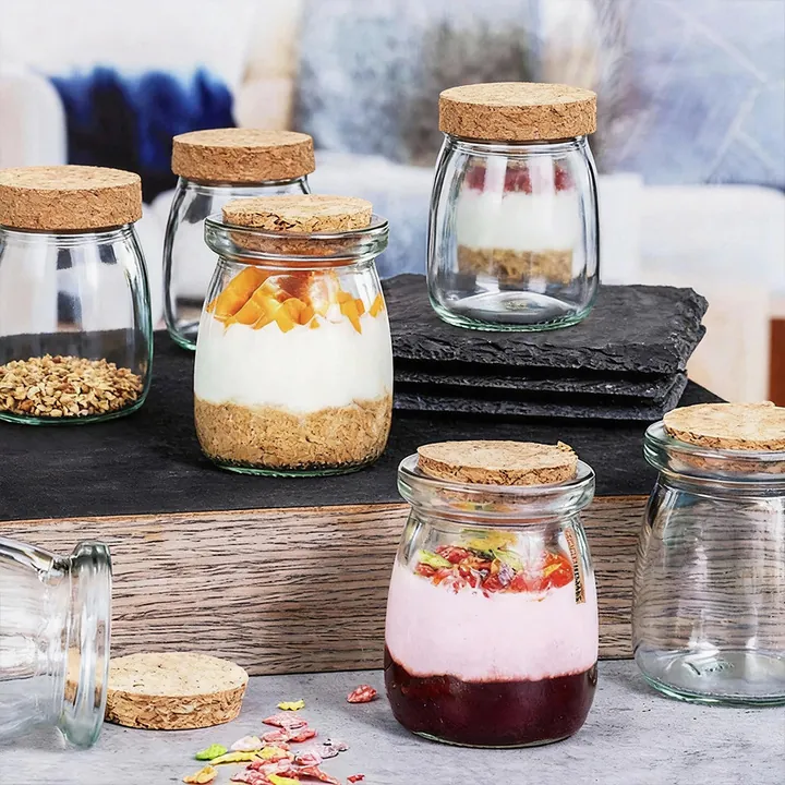 Cork lid glass yogurt jars displayed with cereal and dessert in a food scene